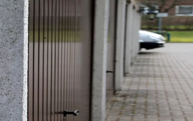 Mehrere Braune Rollgaragentore an aneinandergereihten Garagen.